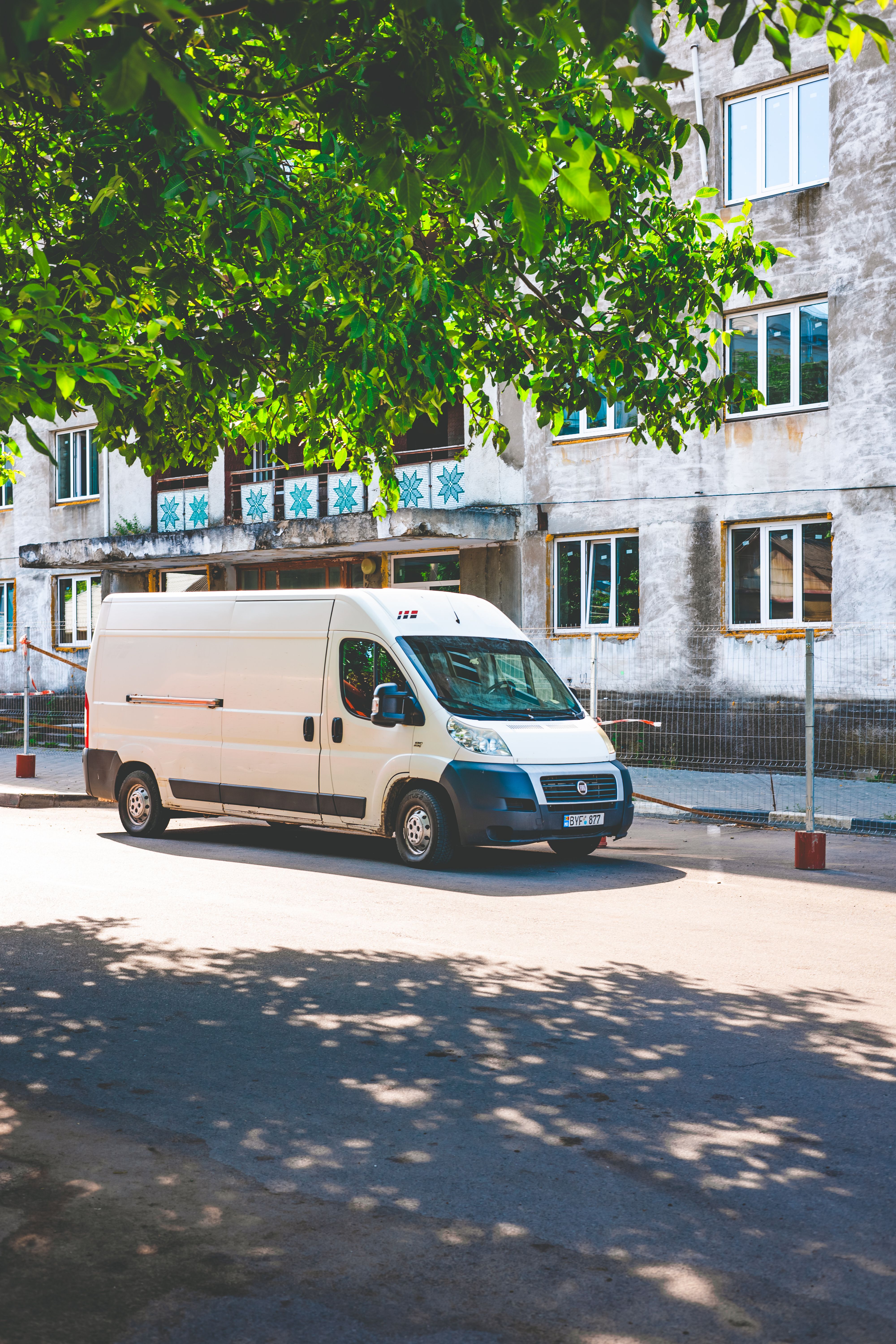 Veículo utilitário branco de entrega estacionado em via urbana